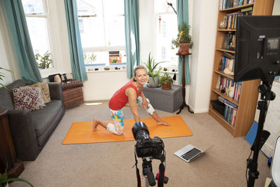 Fitness woman doing exercise video recording with camera at home