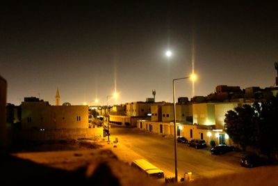 View of road along buildings at night