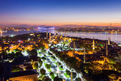 High angle view of city lit up at night