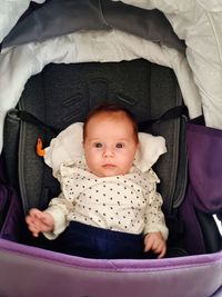 High angle view of cute baby girl sleeping in baby carriage at home