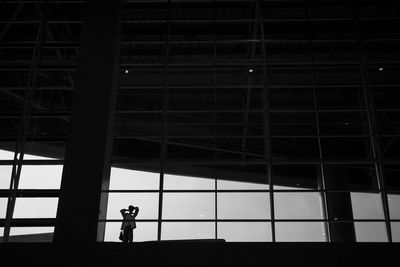 Low angle view of silhouette man standing against building