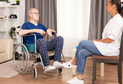 Friends sitting on chair at home