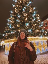 Portrait of young woman standing in city during winter