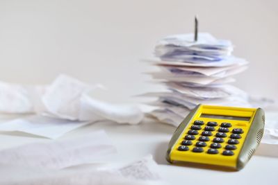 Close-up of bills and calculator on table