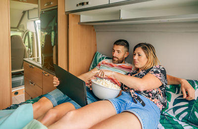 Portrait of happy family sitting on sofa at home