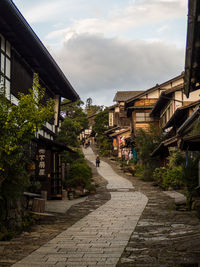 Street amidst buildings in town against sky