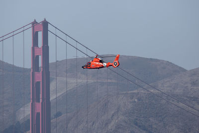 Low angle view of overhead cable car against sky