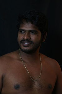 Portrait of handsome young man against black background