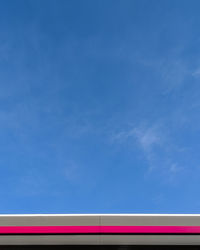 Low angle view of multi colored lights against blue sky