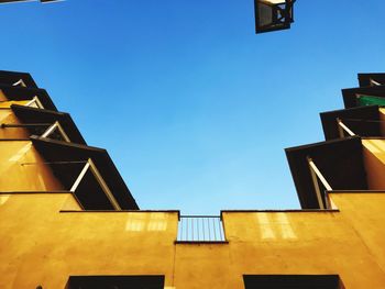 Low angle view of residential buildings against clear blue sky