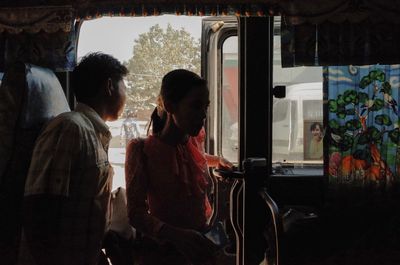 Rear view of people looking through window