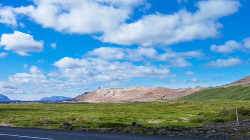 Scenic view of landscape and mountains against blue sky
