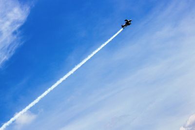 Low angle view of airplane flying against blue sky