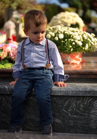 Little toddler sitting on a grave mourning