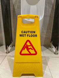 High angle view of warning sign on tiled floor