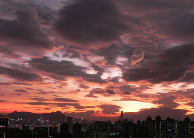 High section of illuminated cityscape against dramatic sky