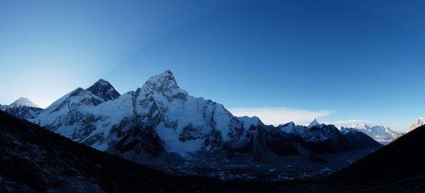 Scenic view of snowcapped mountains against blue sky