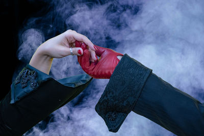 Midsection of person holding smoke emitting from rock