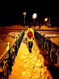 Rear view of man walking on snow