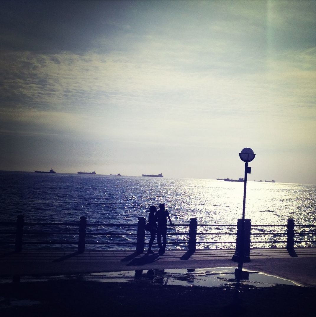 sea, horizon over water, water, silhouette, sky, beach, tranquil scene, tranquility, scenics, shore, beauty in nature, nature, men, leisure activity, standing, rear view, lifestyles, idyllic, full length