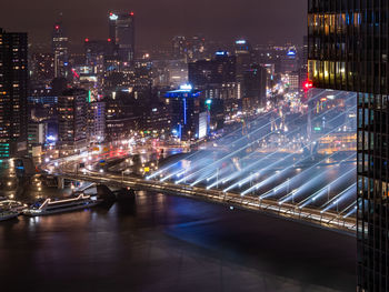 High angle view of illuminated city by river at night