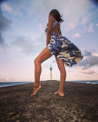 Full length of woman on beach against sky