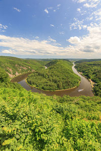 Scenic view of road amidst field against sky