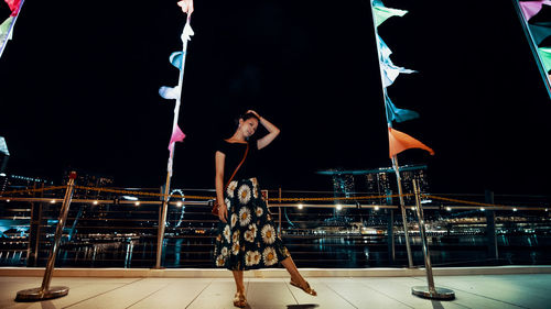 People standing on illuminated railing at night