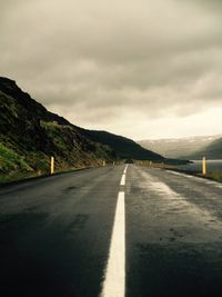 Empty road with mountain range in background