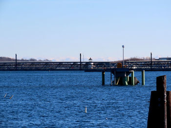 Pier on river against clear sky
