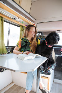 Woman traveling with dog in camper van