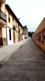 Alley amidst buildings against clear sky