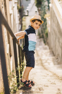 Portrait of cute boy wearing hat standing on steps
