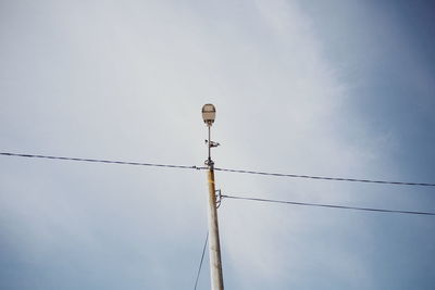 Low angle view of electricity pylon against sky