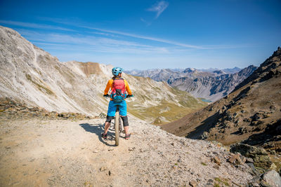 Rear view of man riding motorcycle on mountain