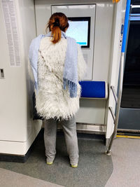 Rear view of woman standing in corridor