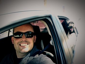 Portrait of man wearing sunglasses in car