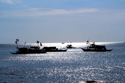 Boats sailing in sea against sky