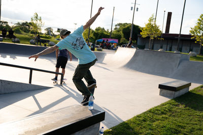 Rear view of man skateboarding in city