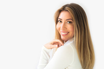 Portrait of smiling young woman against white background