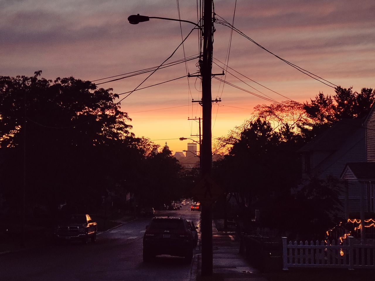 CARS ON ROAD AGAINST SKY AT SUNSET