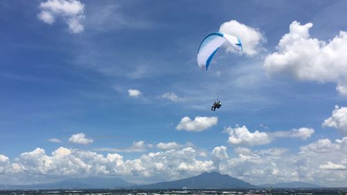 Low angle view of paragliding against sky