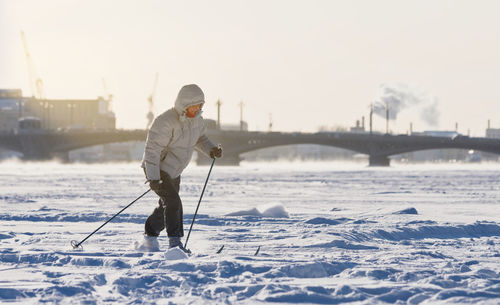 Man standing on snow against sky during winter