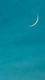 Low angle view of moon against blue sky