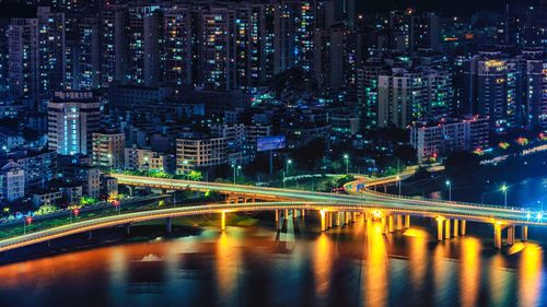 Illuminated bridge and buildings in city at night