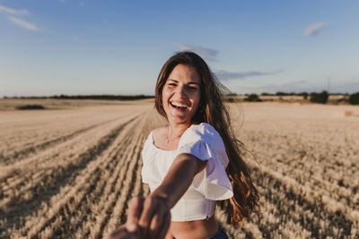 Portrait of a smiling young woman on field