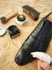 Cropped hand of person polishing black shoe