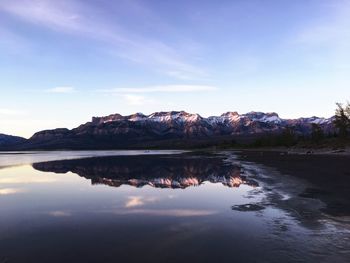 Scenic view of lake by mountains against sky