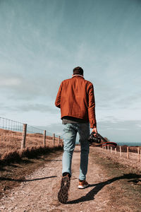 Rear view of man walking on field