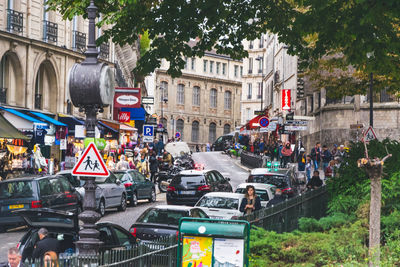 Cars on road by buildings in city